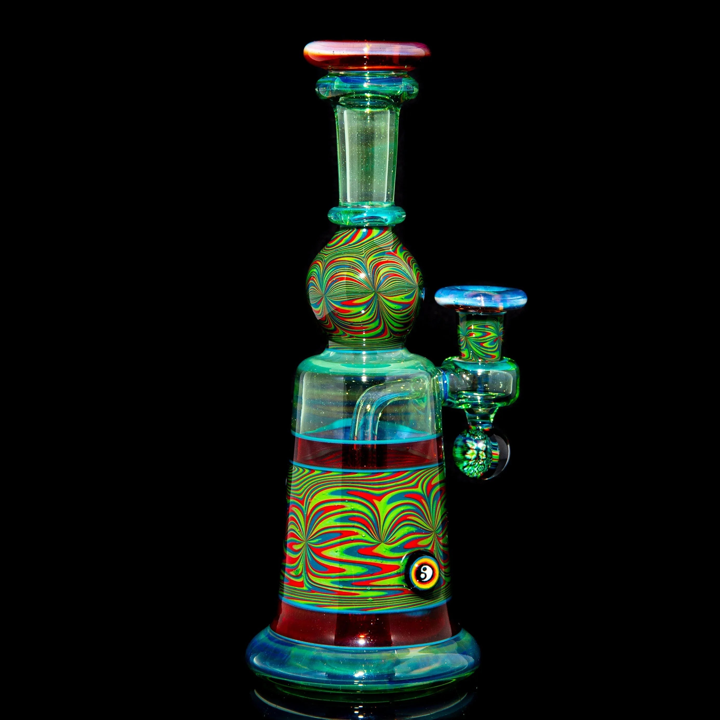 Heady glass water pipe with vibrant swirl patterns against a black background