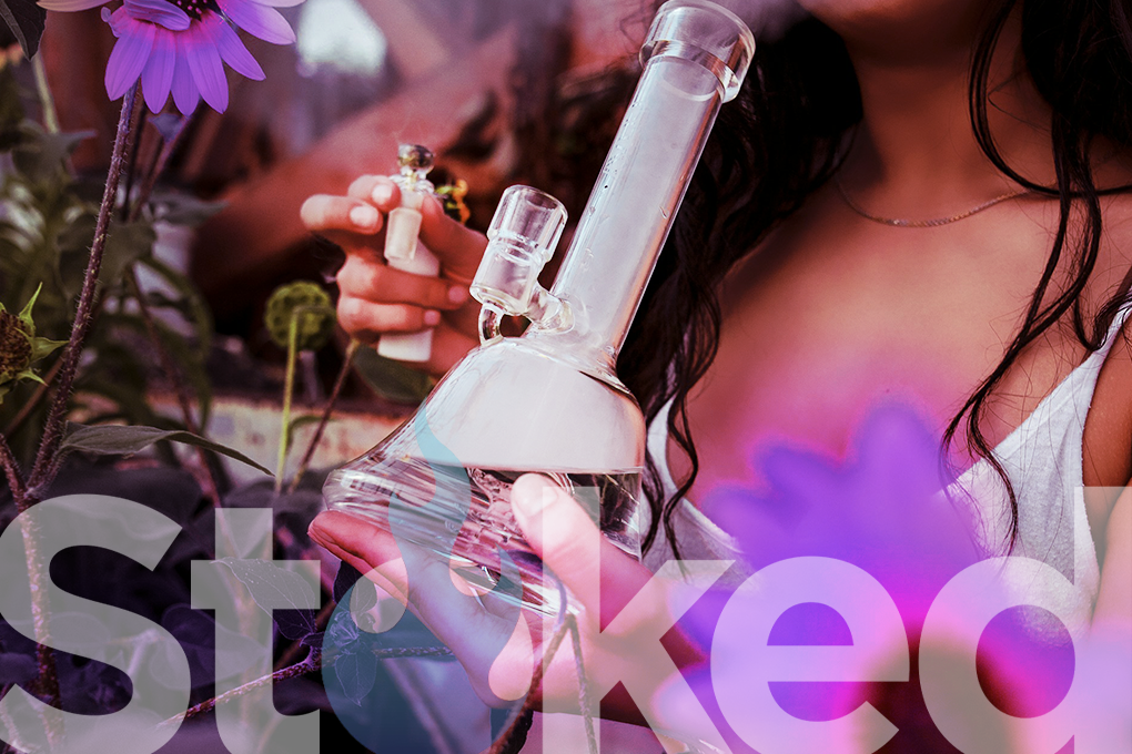 Woman taking a hit from a glass bong.