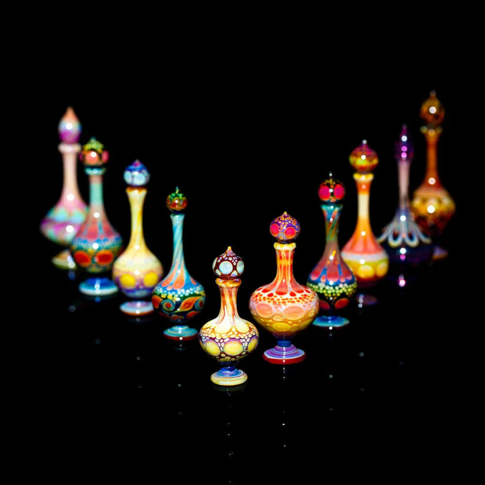 Colorful hand-blown glass perfume bottles with intricate designs on a black background