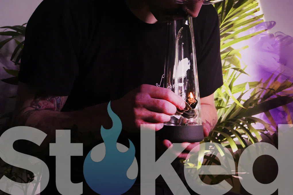 Person taking a hit from a glass bong.