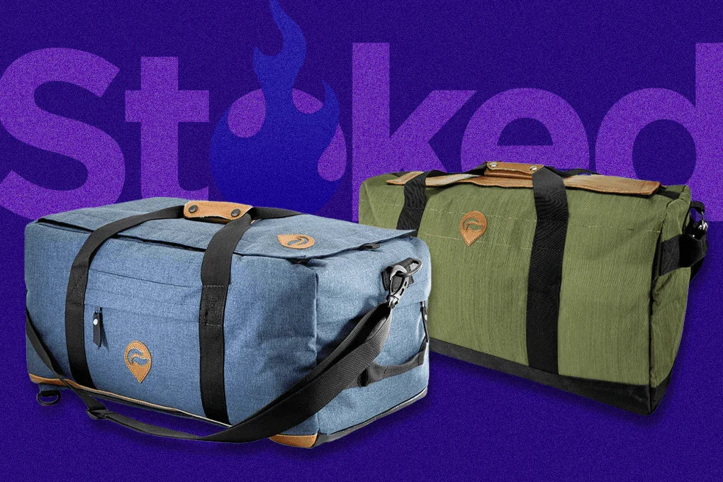 Blue and green duffel bags with black straps on a purple background