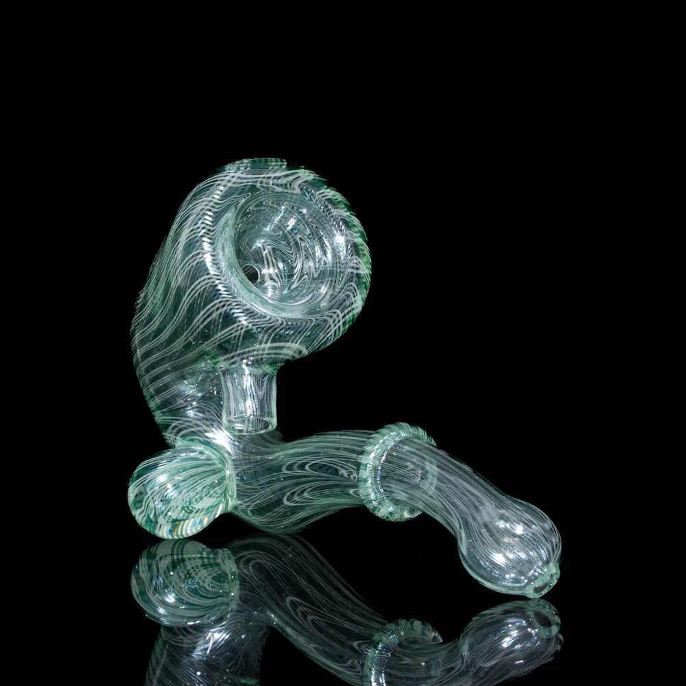 Intricate clear glass hand pipe with swirling designs on a black background