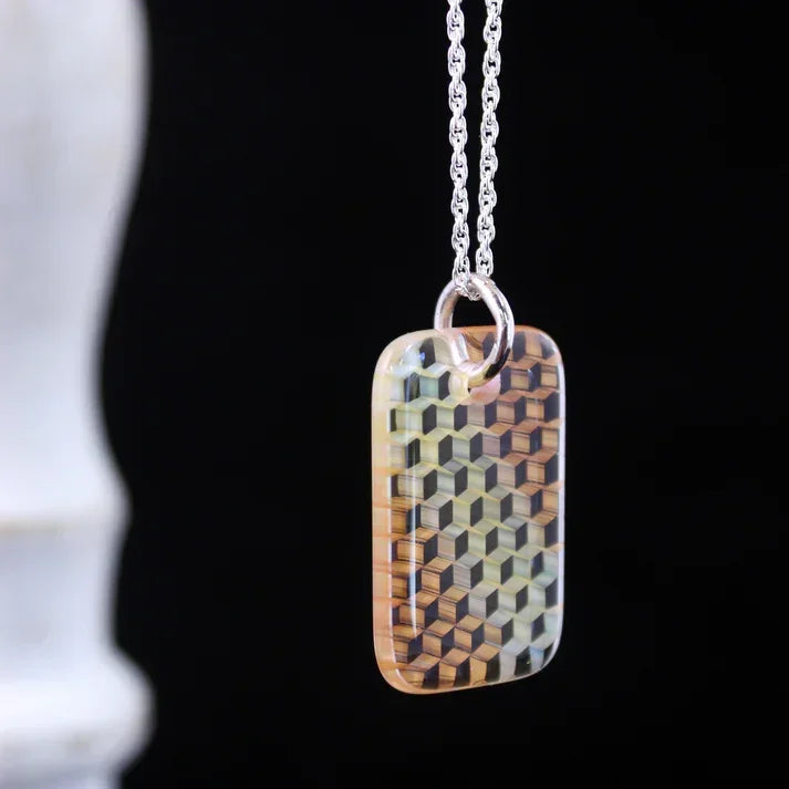 Glass pendant necklace with geometric cube design on silver chain, black background