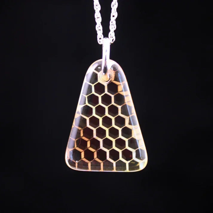 Glass pendant necklace with honeycomb pattern on black background