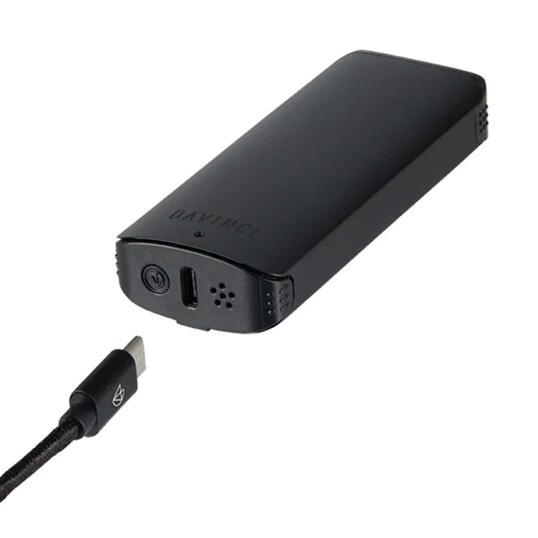 DaVinci portable vaporizer in black with USB-C charging cable on white background