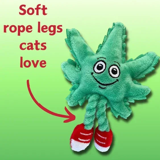 Plush cat toy shaped like a green leaf with rope legs and red shoes on green background.