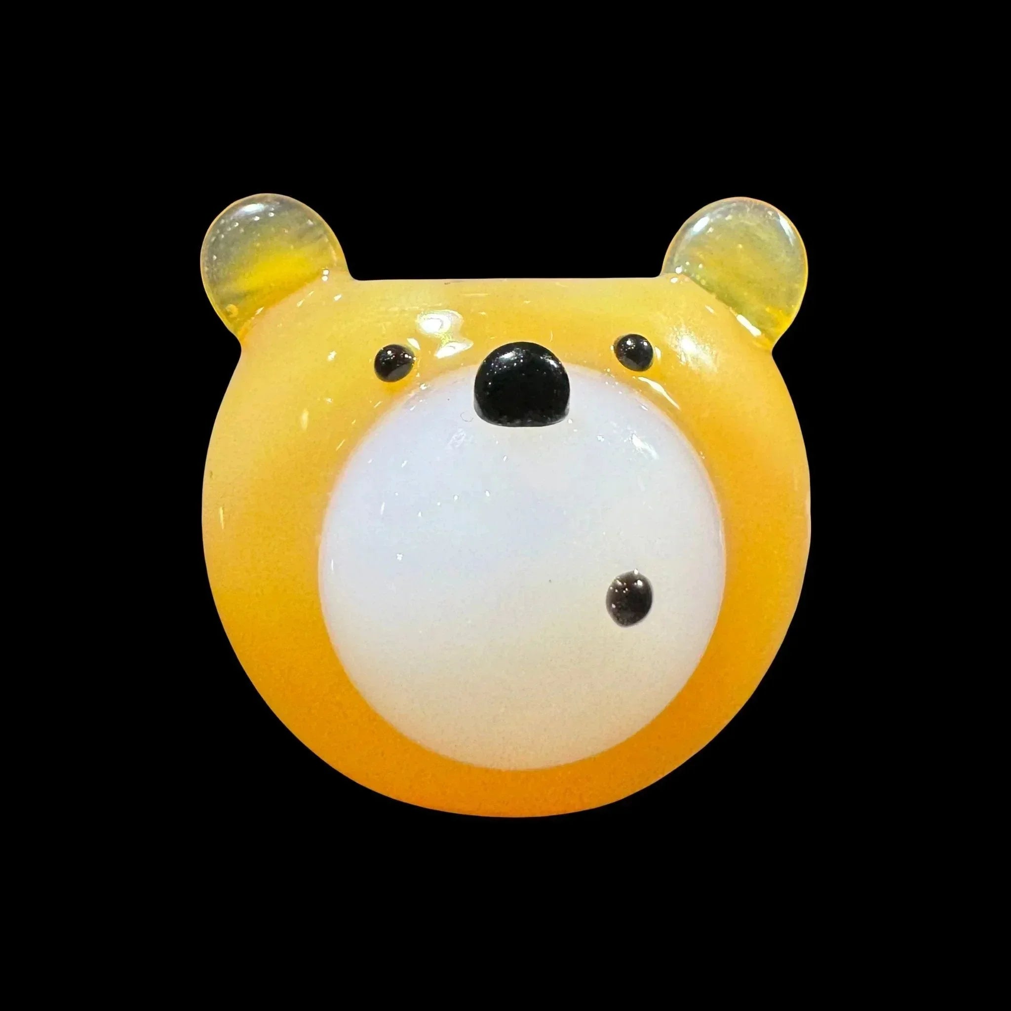 Handmade yellow glass bear carb cap with clear ears on black background