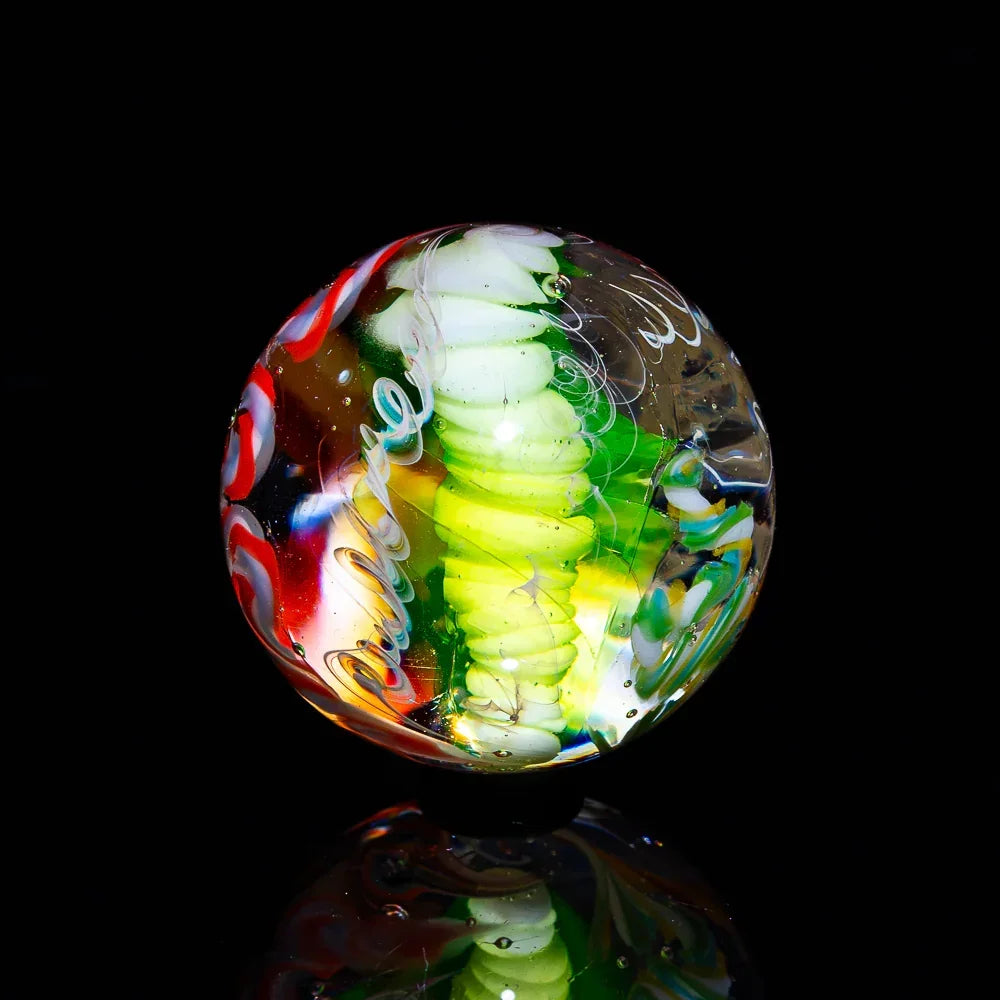 Hand-blown glass marble with colorful swirls and intricate patterns on a black background