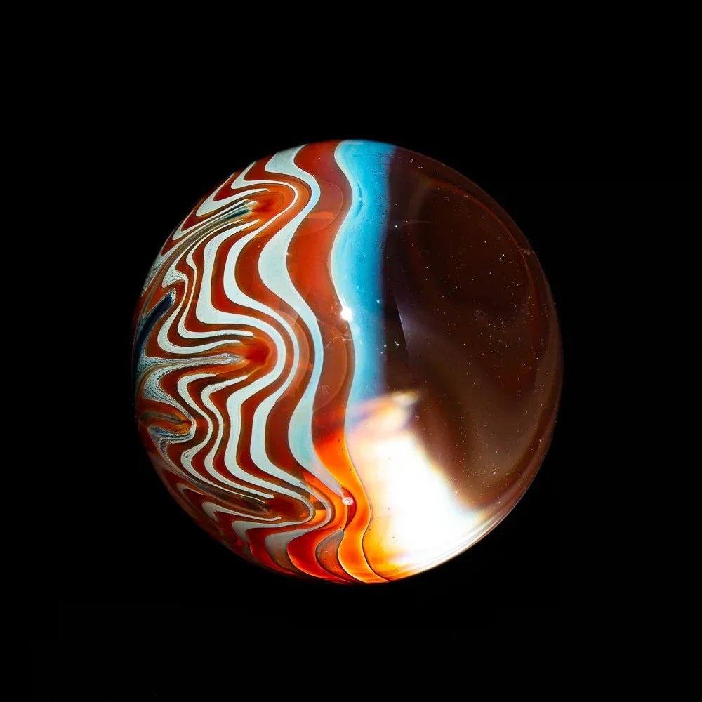 Hand-blown glass marble with red, white, and blue swirl patterns on black background