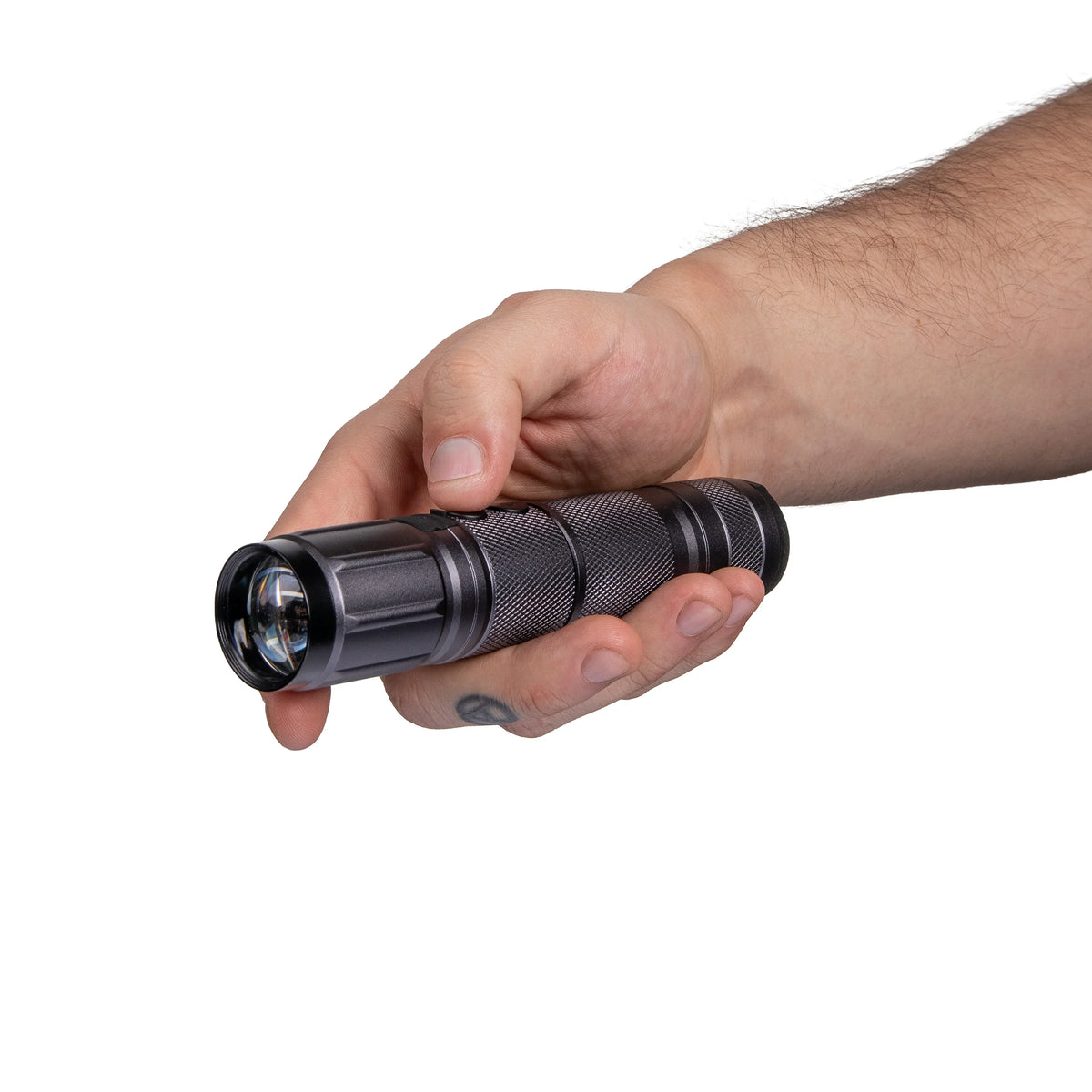 Hand holding a black textured flashlight on white background