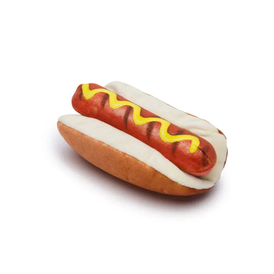 Realistic plush hot dog toy with grill marks and mustard on white background