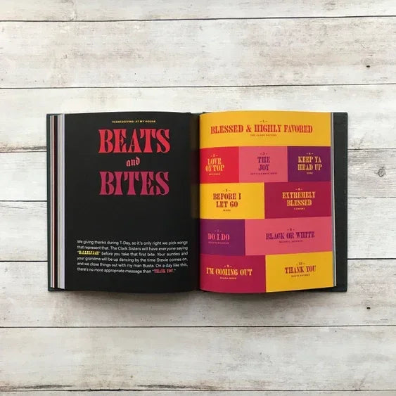 Open book on wood surface showing bold page titles 'Beats and Bites' with colorful song names.