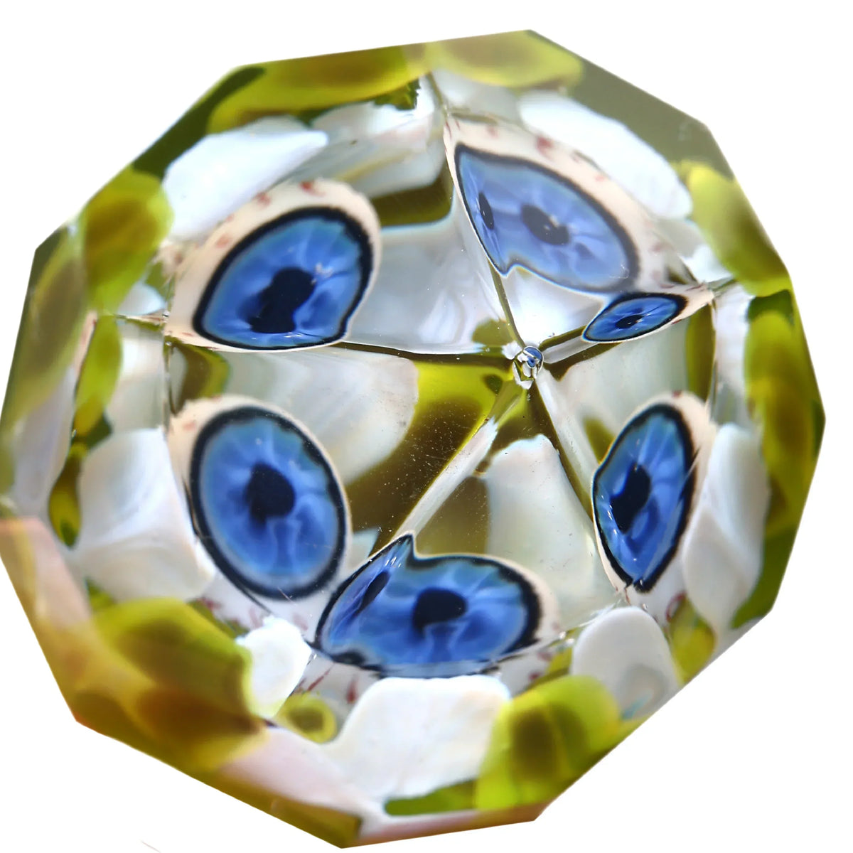 Faceted glass marble with blue eye pattern and green accents, close-up view