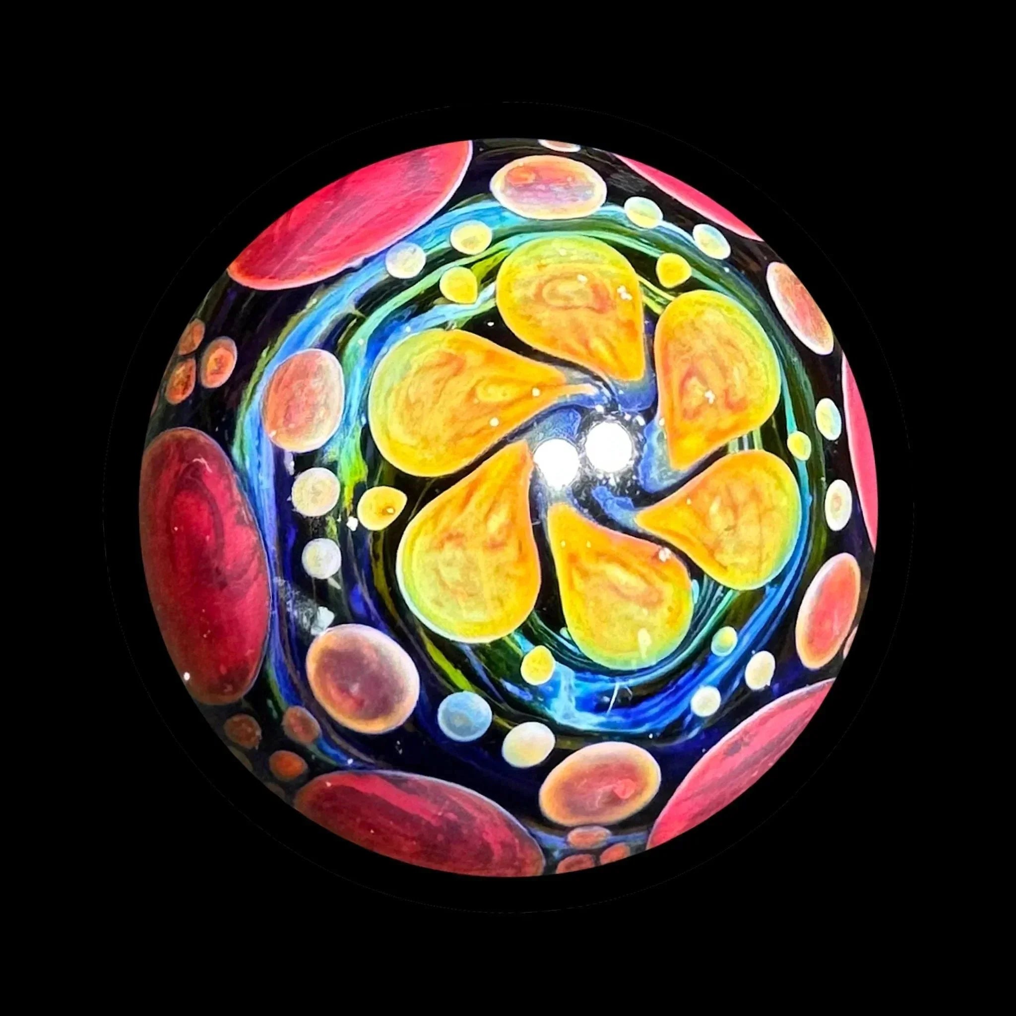 Colorful heady glass marble with abstract yellow, red, and blue swirl patterns