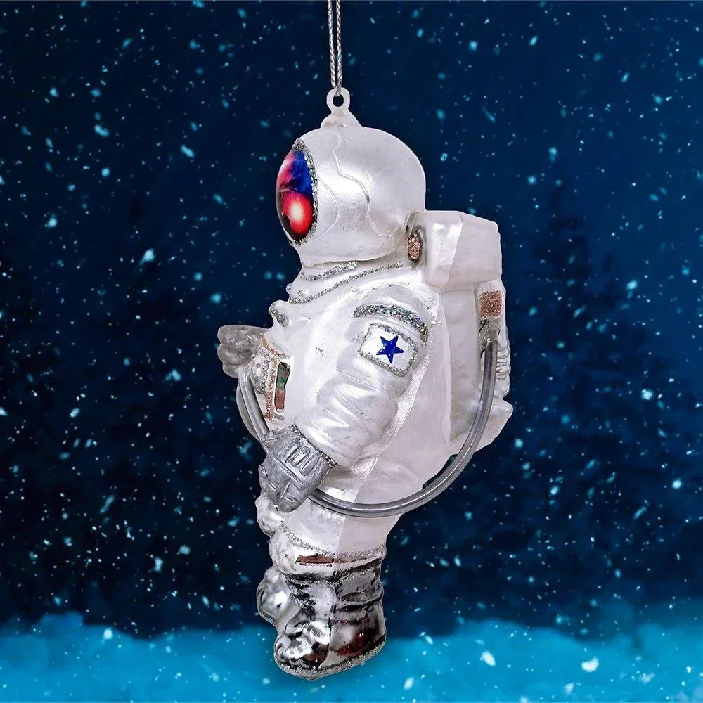 Astronaut ornament with white suit, star patch, and galaxy visor in snowy space background