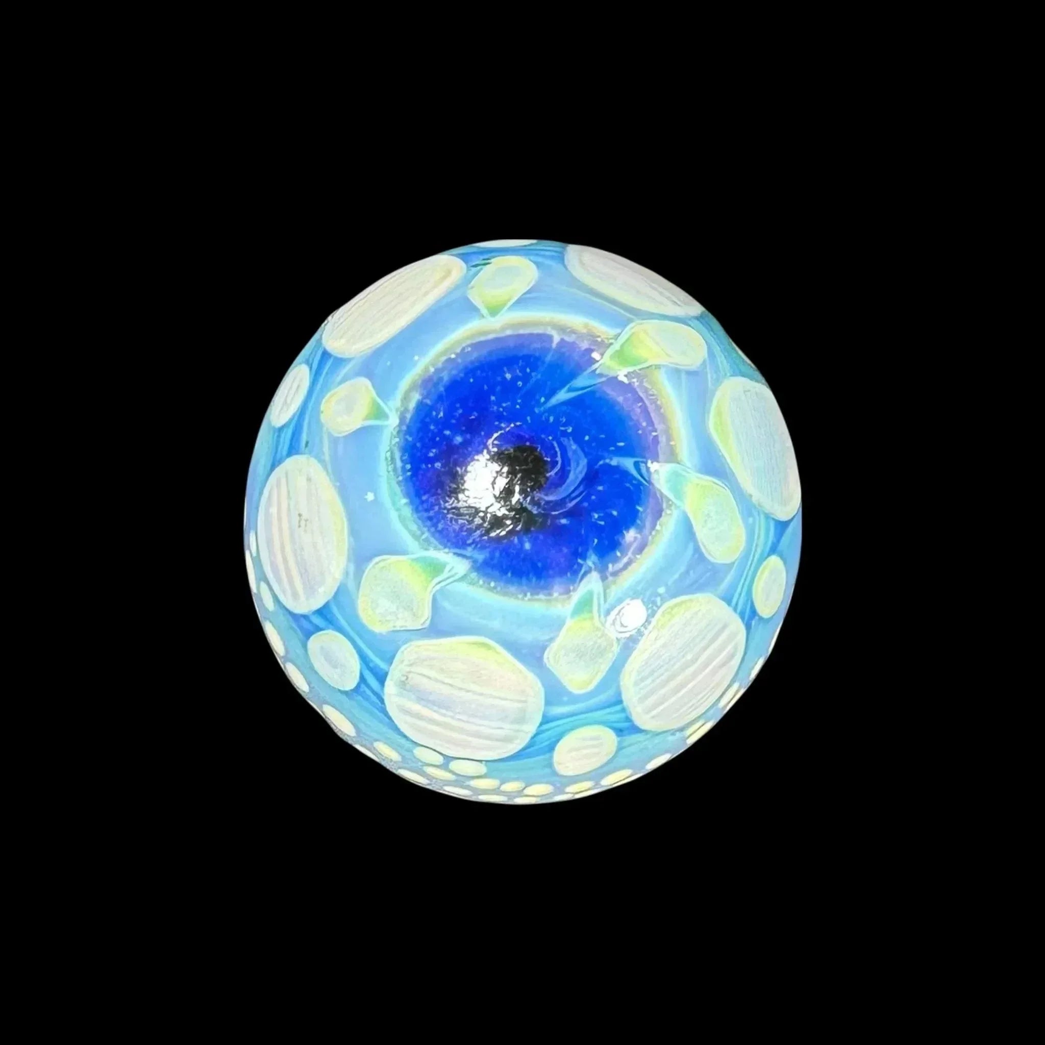 Hand-blown glass marble with blue and white cosmic swirl pattern on black background