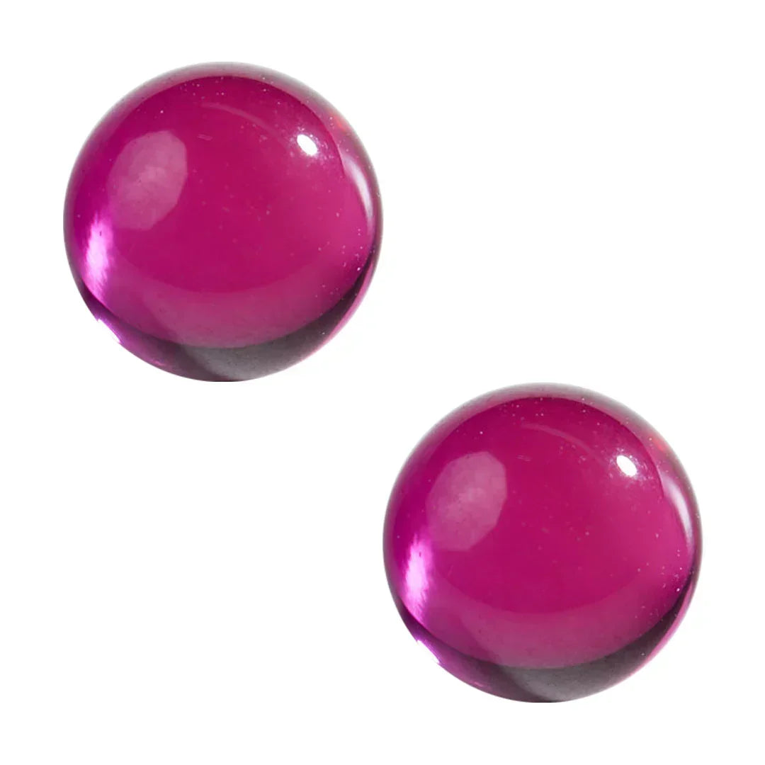 Two ruby terp pearls for dab rigs and quartz bangers on a white background