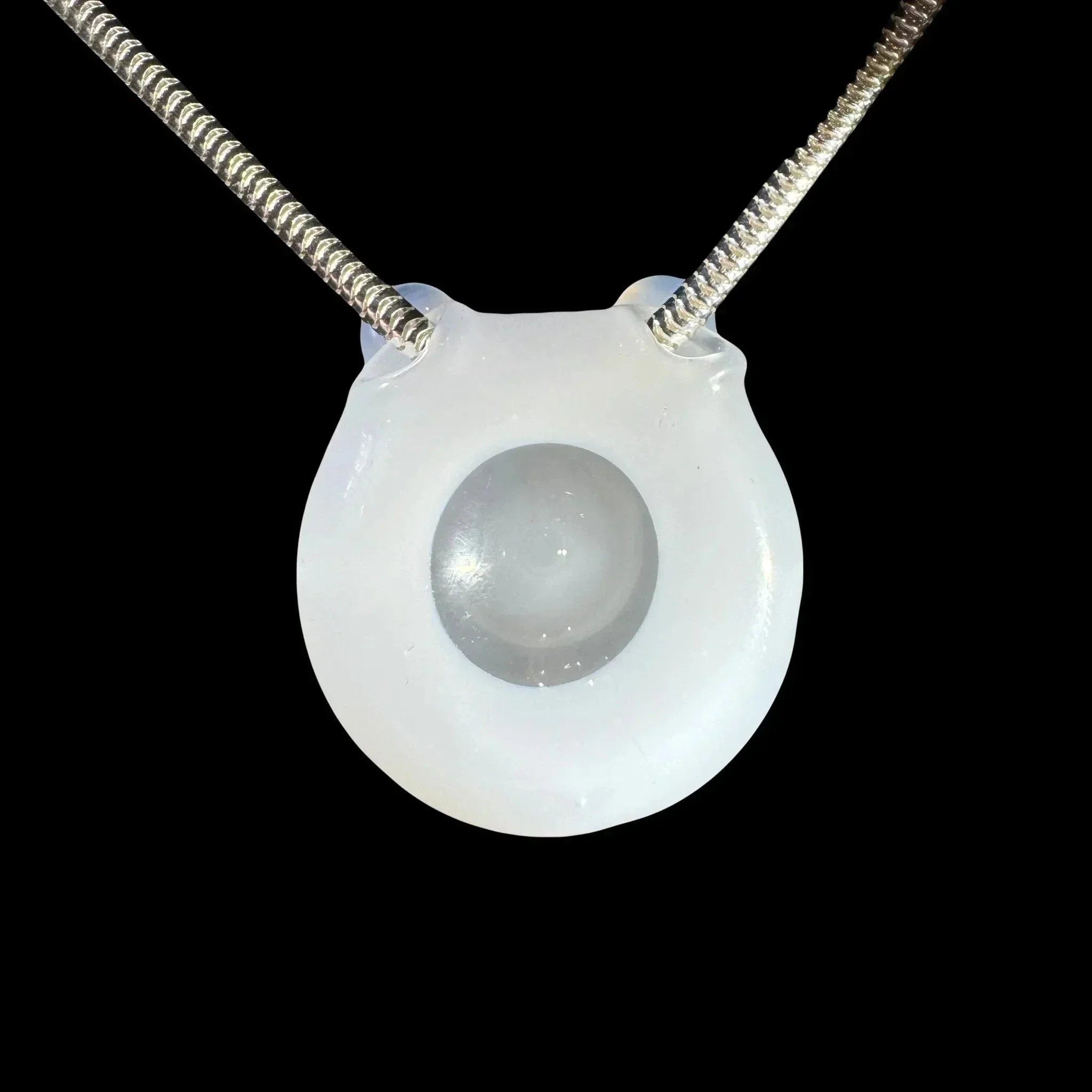 Frosted glass pendant with silver chain, featuring a clear center orb, on black background.