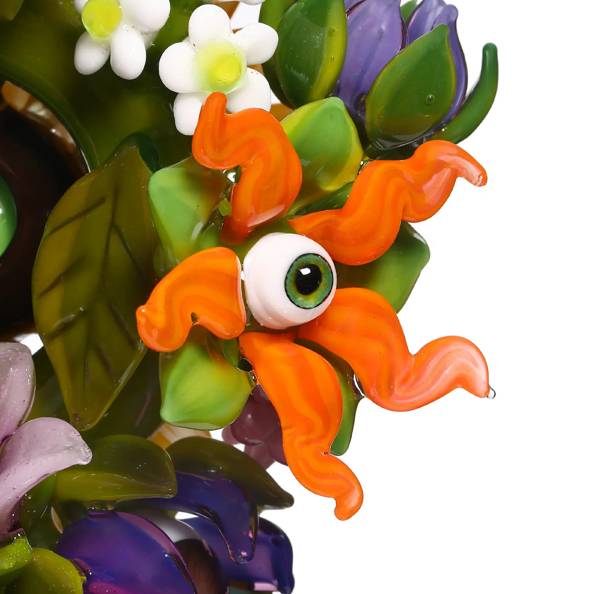 Colorful glass art flower with orange petals, green leaves, and central eye design