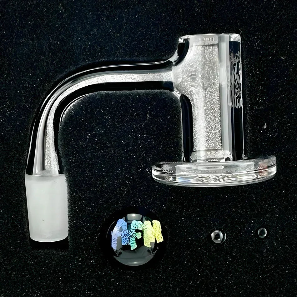 Clear glass quartz banger set with colorful marble cap and two terp pearls on black background