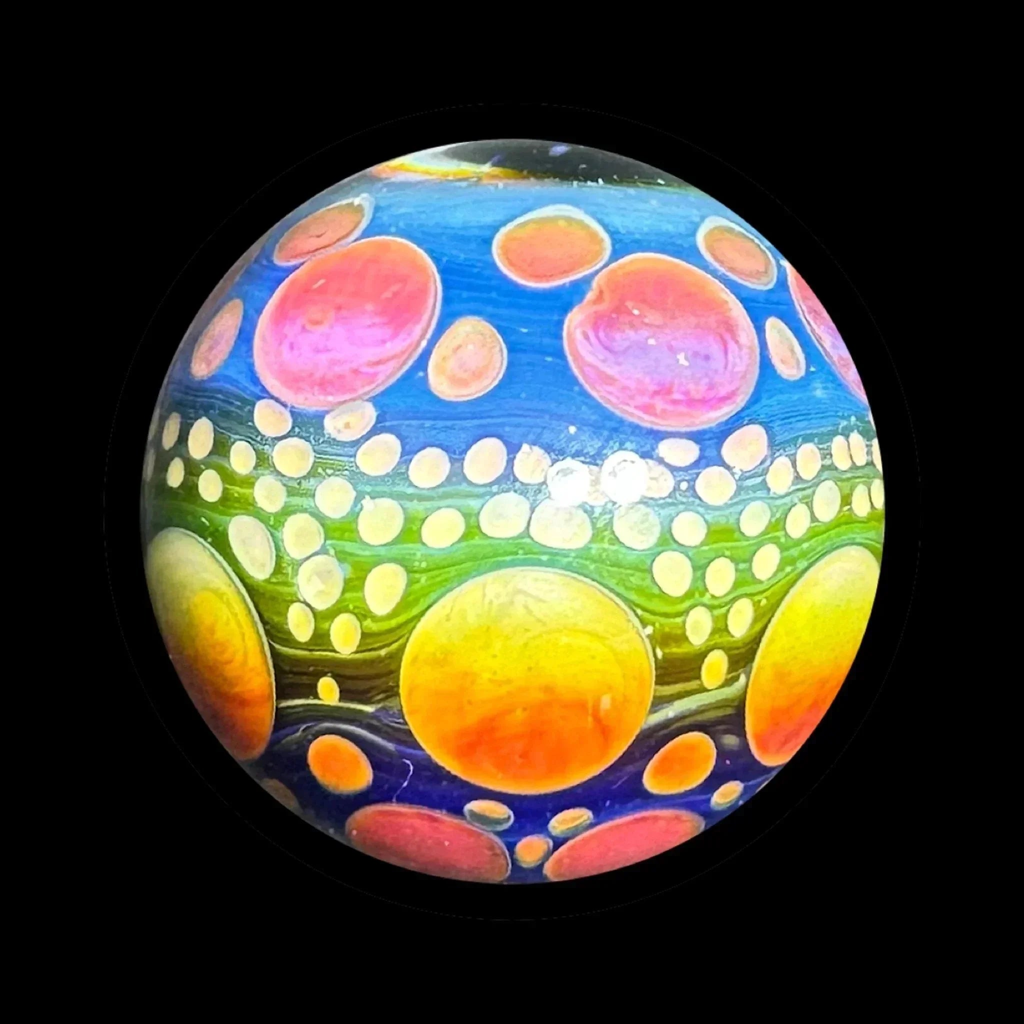 Colorful glass marble with vibrant rainbow and bubble patterns on black background