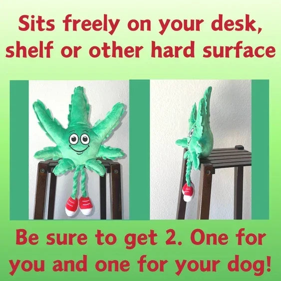 Plush green leaf character with red shoes sitting on a chair, smiling, desk accessory toy.