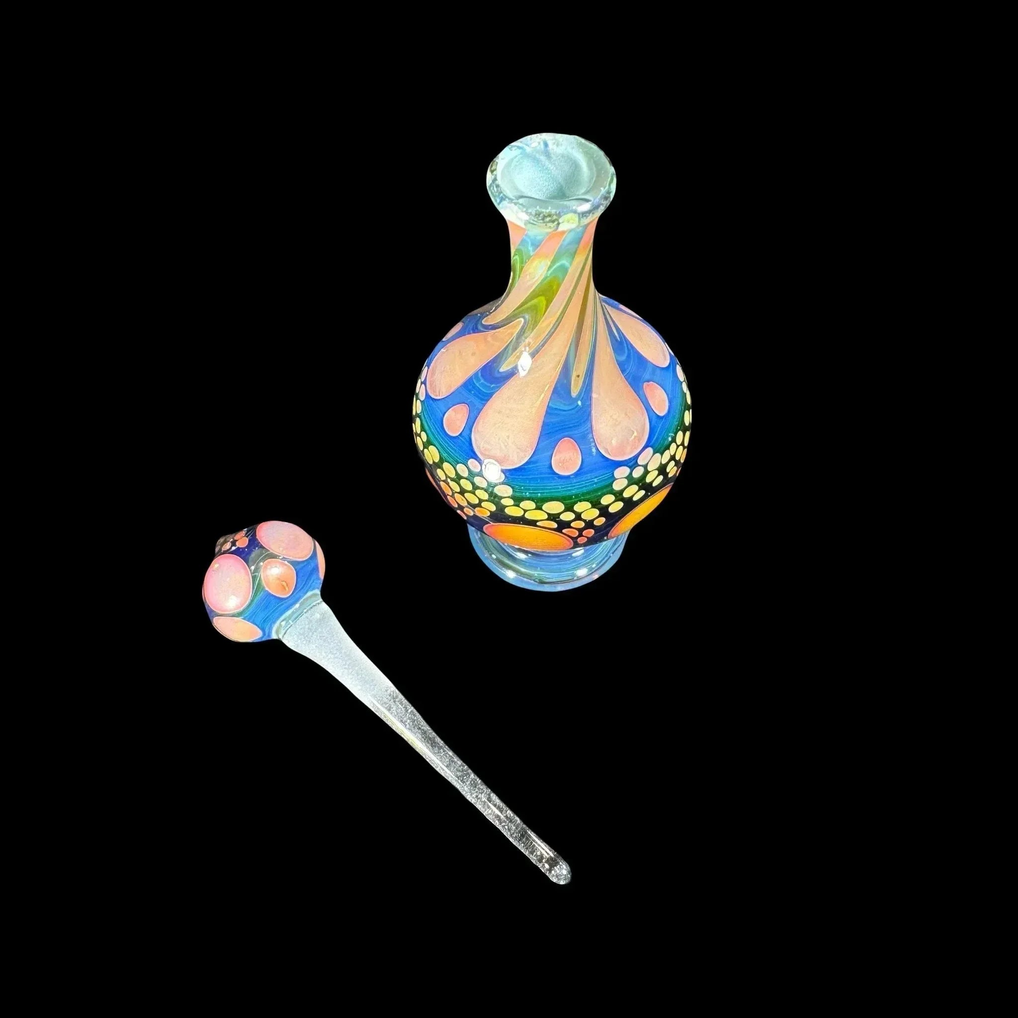 Colorful heady glass decanter and matching wand with vibrant swirl and dot patterns on black