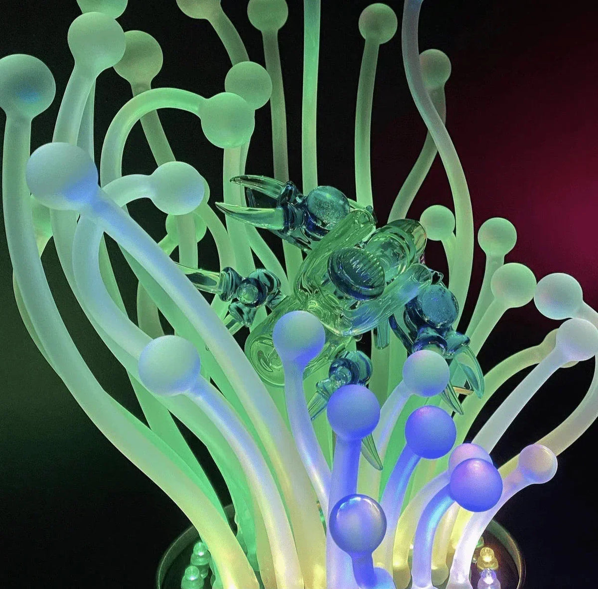 Heady glass art piece with glowing tentacle-like shapes and a detailed glass crab sculpture