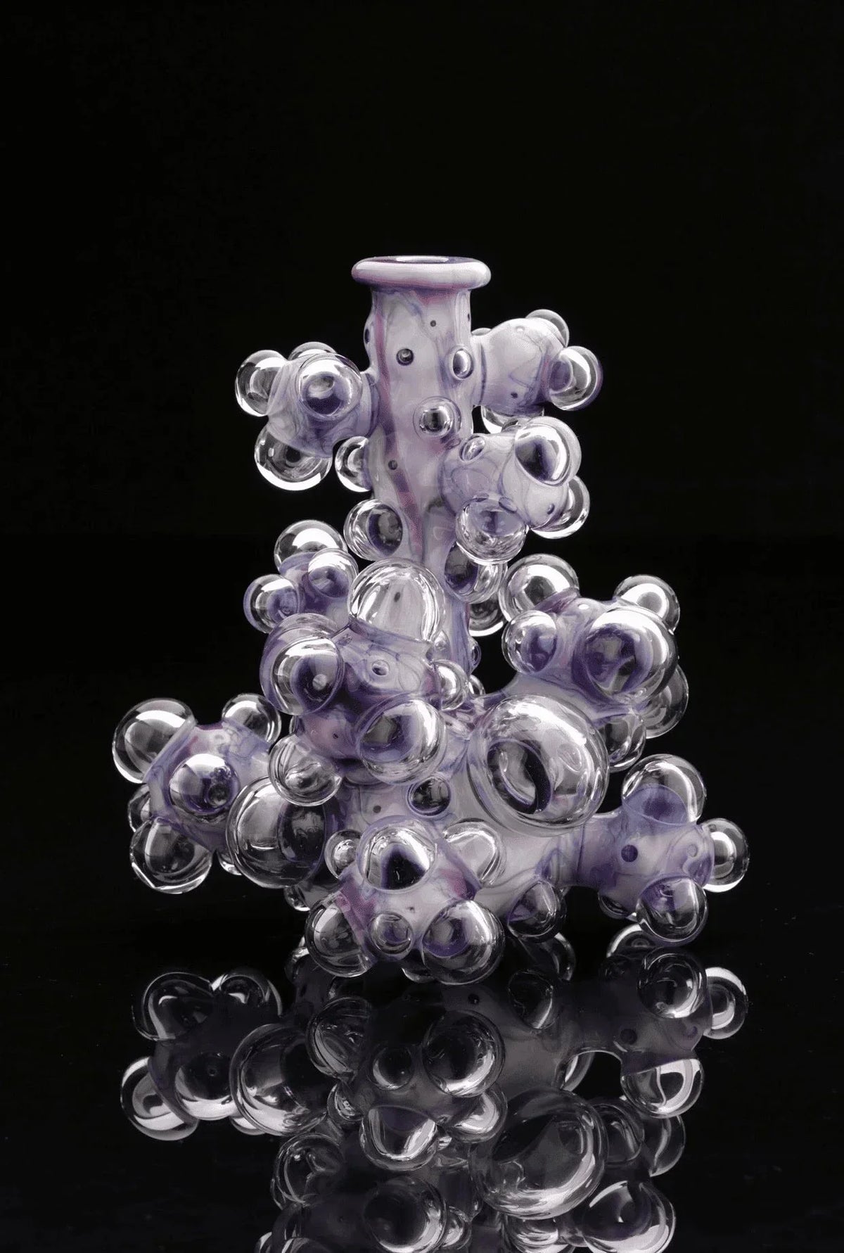 Purple and clear heady glass water pipe with bubble accents on black background