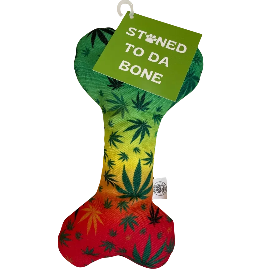 Colorful bone-shaped dog toy with leaf pattern and a tag reading 'STONED TO DA BONE'.