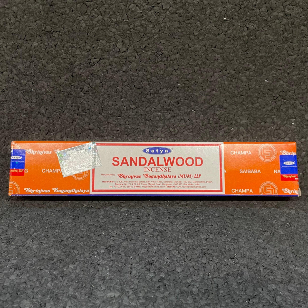 Satya Sandalwood incense box on black textured surface, orange and white packaging
