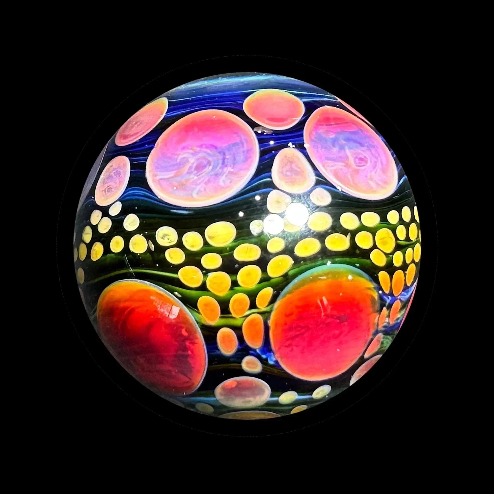 Colorful heady glass marble with vibrant swirling patterns and bubble details on black background