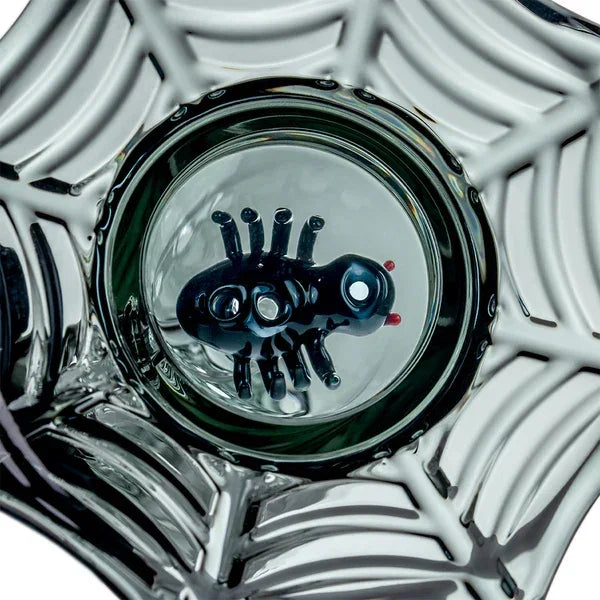 Intricate glass cup with spider design at the base and web pattern detailing