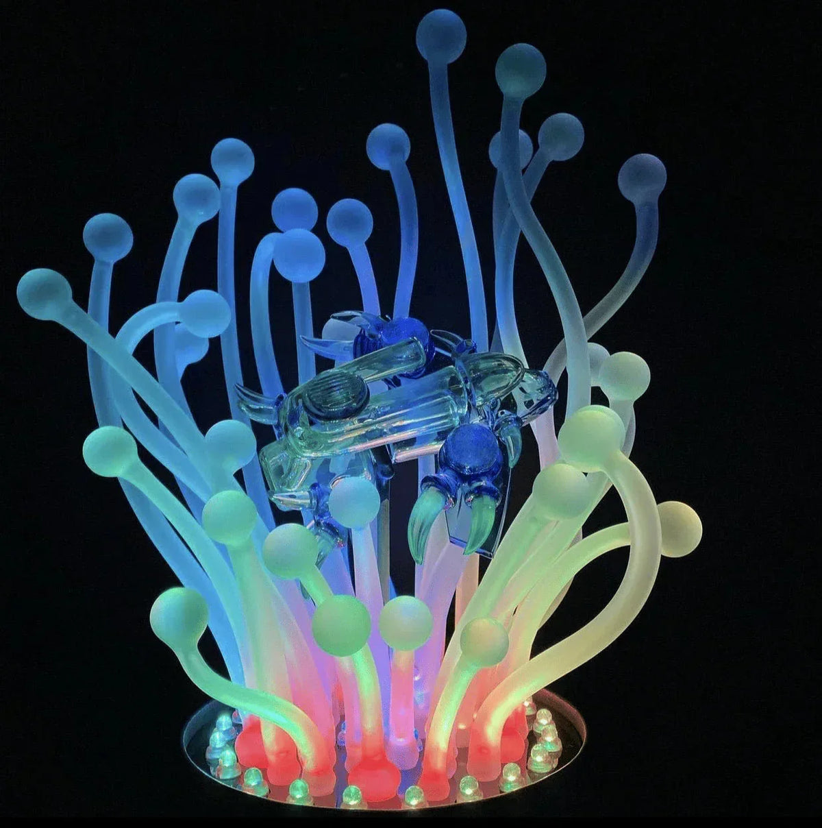 Colorful glass crab sculpture with glowing anemone-like stems and LED lighting