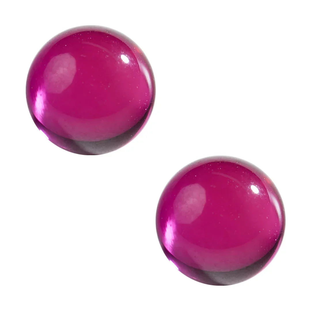 Two vibrant purple glass terp pearls on a white background for dab accessories