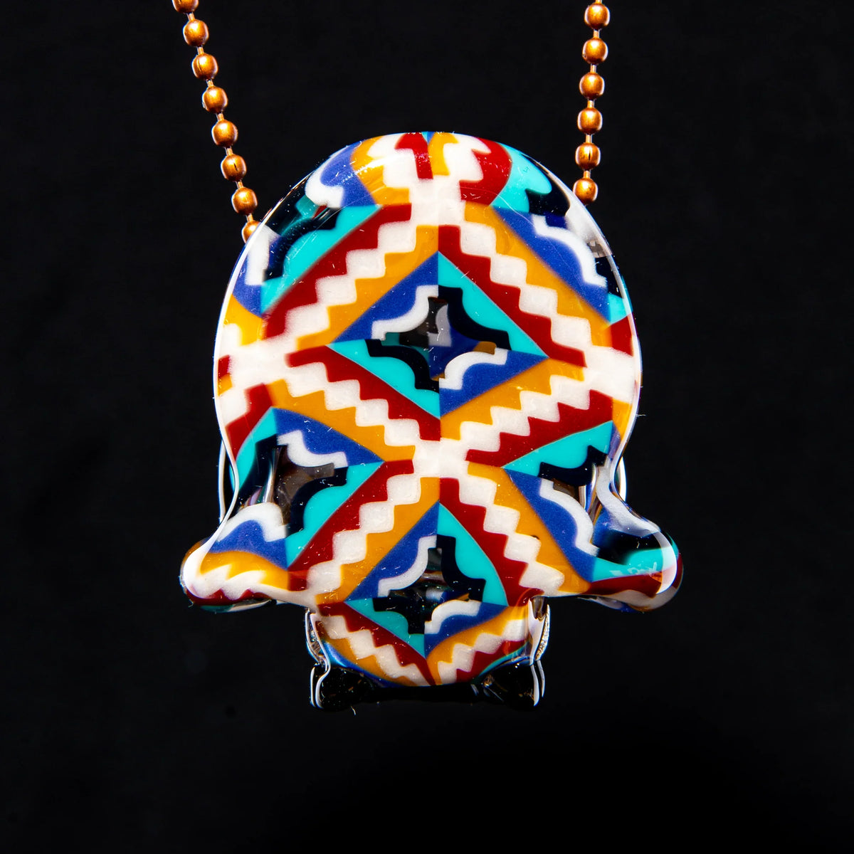 Colorful patterned glass pendant with geometric zigzag design on gold beaded chain