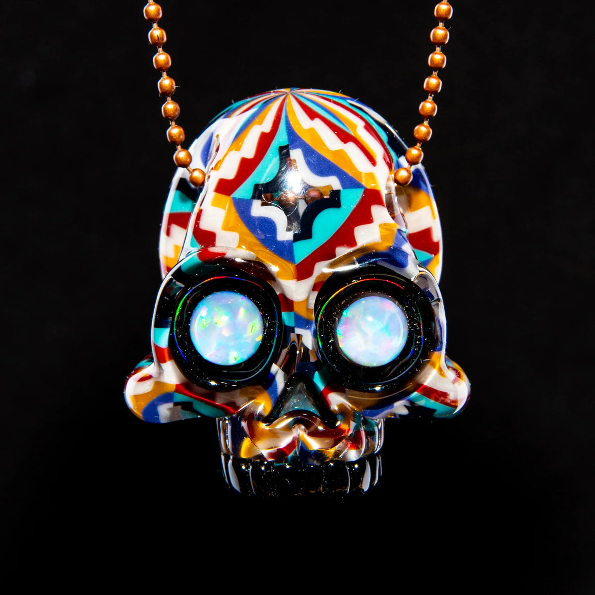 Colorful glass skull pendant with opal eyes and geometric patterns on a beaded chain