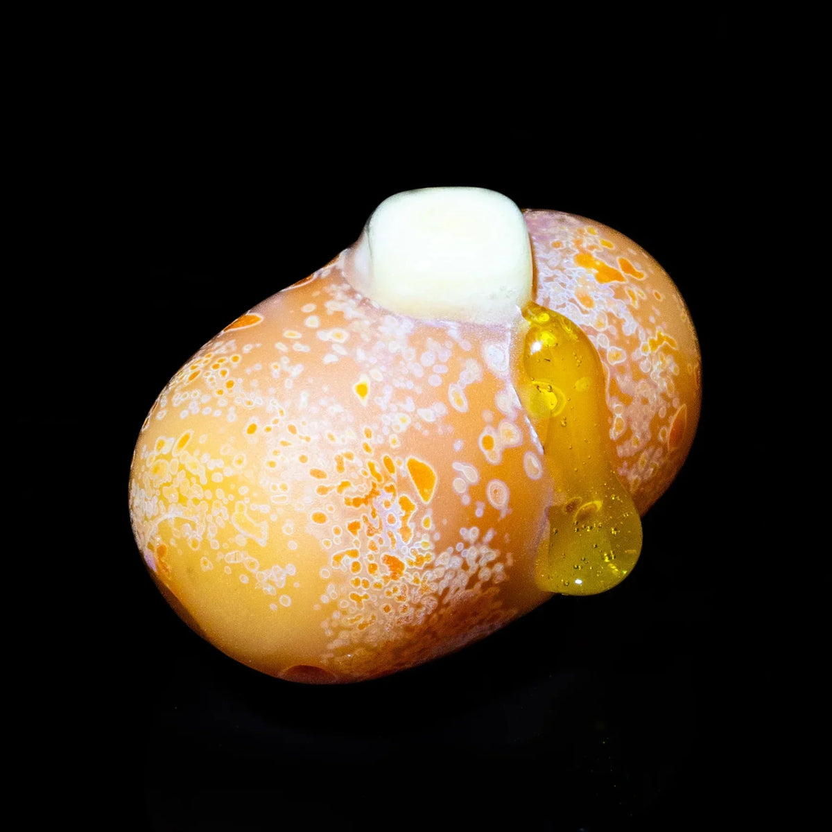 Hand-blown glass pocket pipe shaped like a buttered baked potato on black background