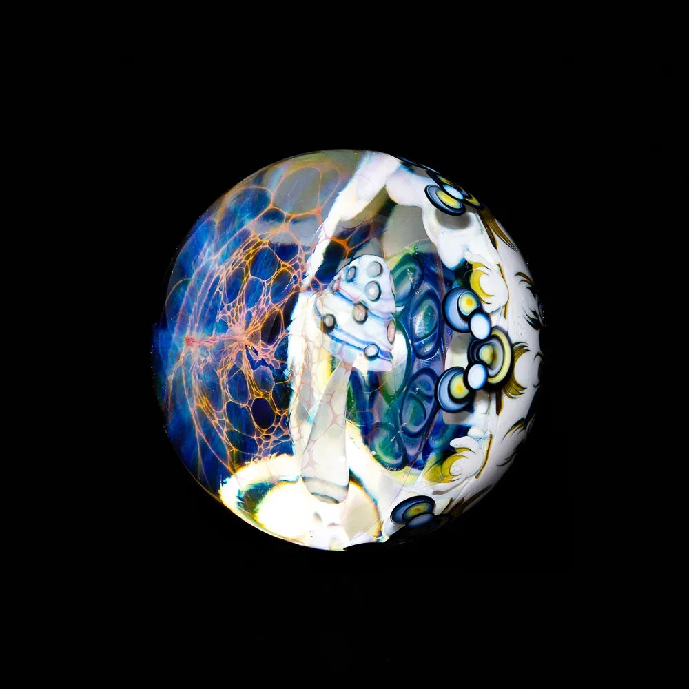 Artistic glass marble featuring intricate colorful patterns and mushroom design on black background