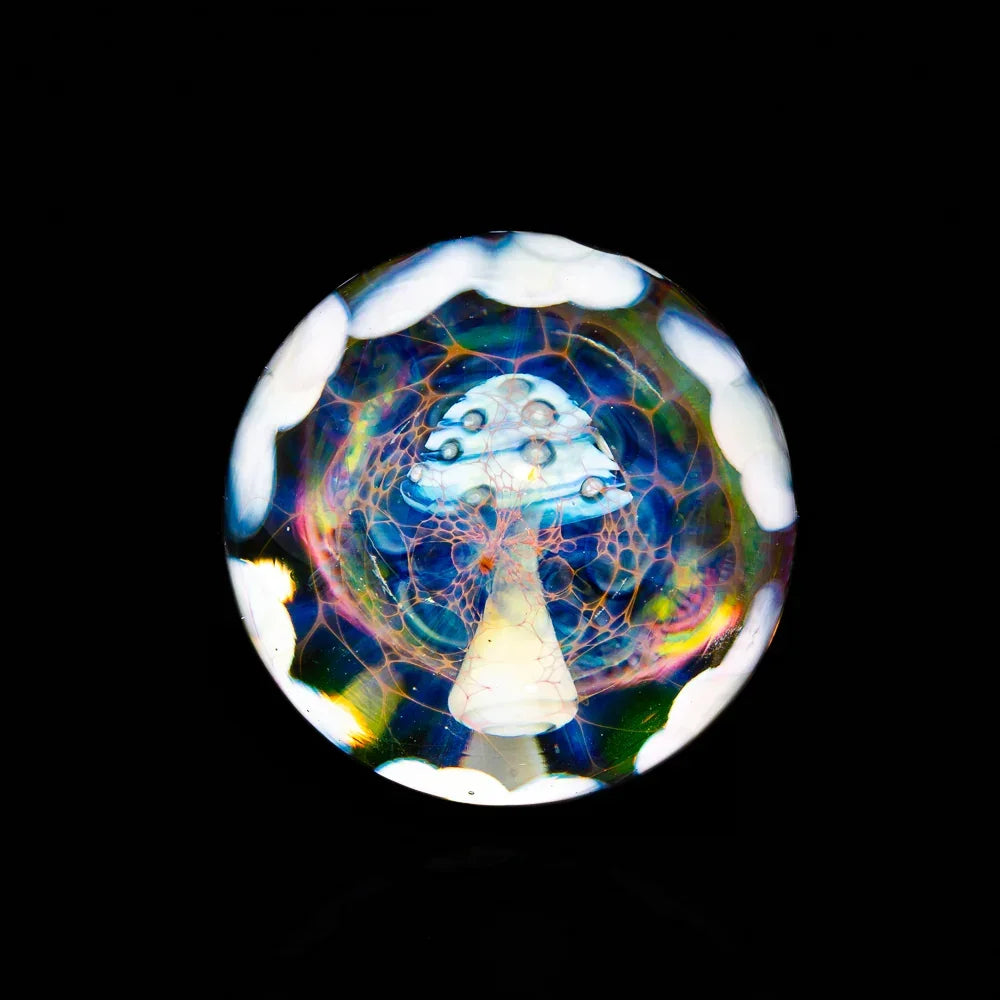 Handcrafted glass marble featuring a white mushroom design with colorful patterns on black background