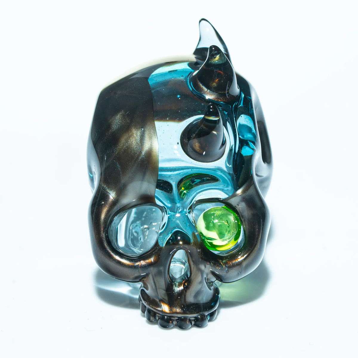 Glass skull pendant with metallic spikes and green eye detail on white background