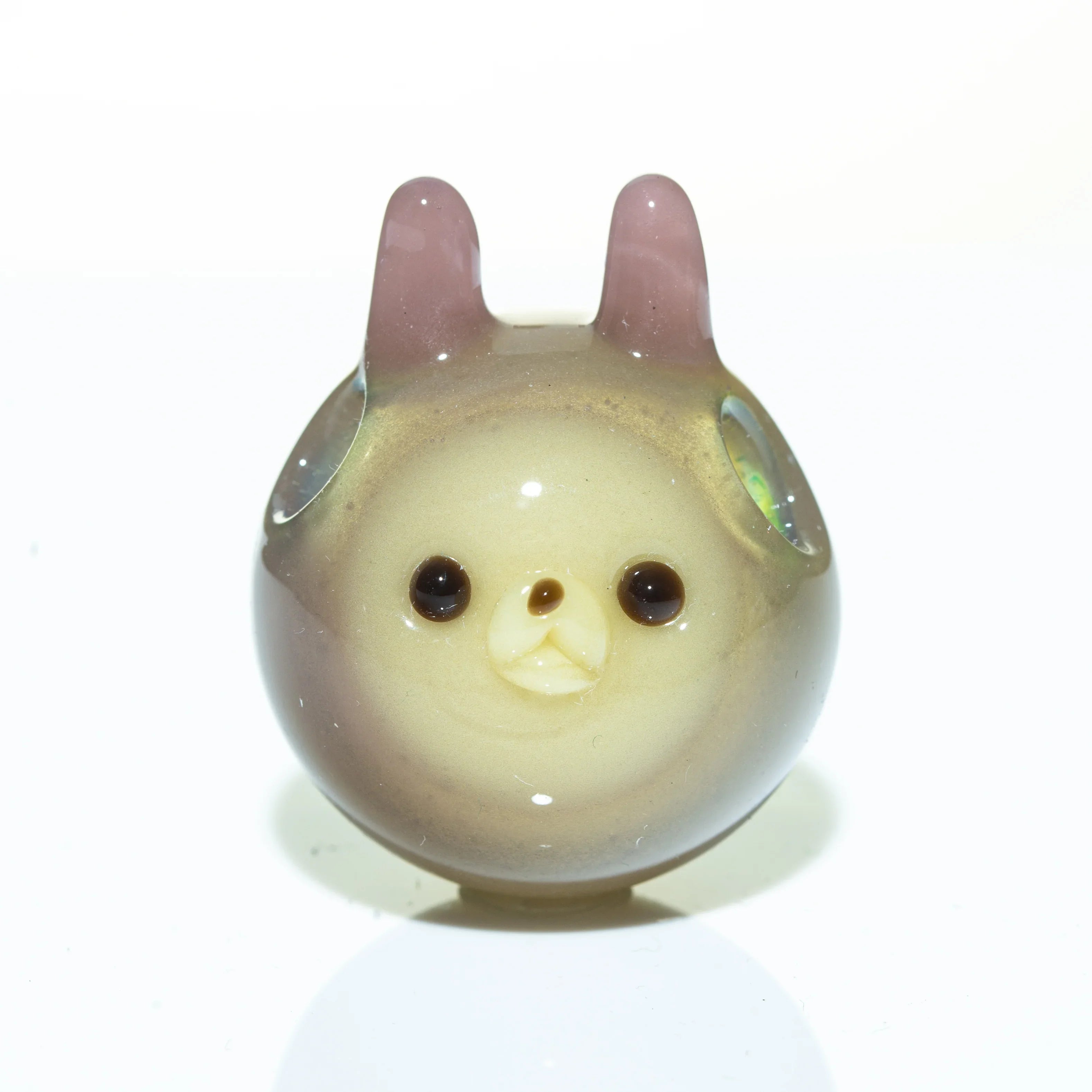Pastel glass pendant shaped like a round animal with ears and a cute face, on white background