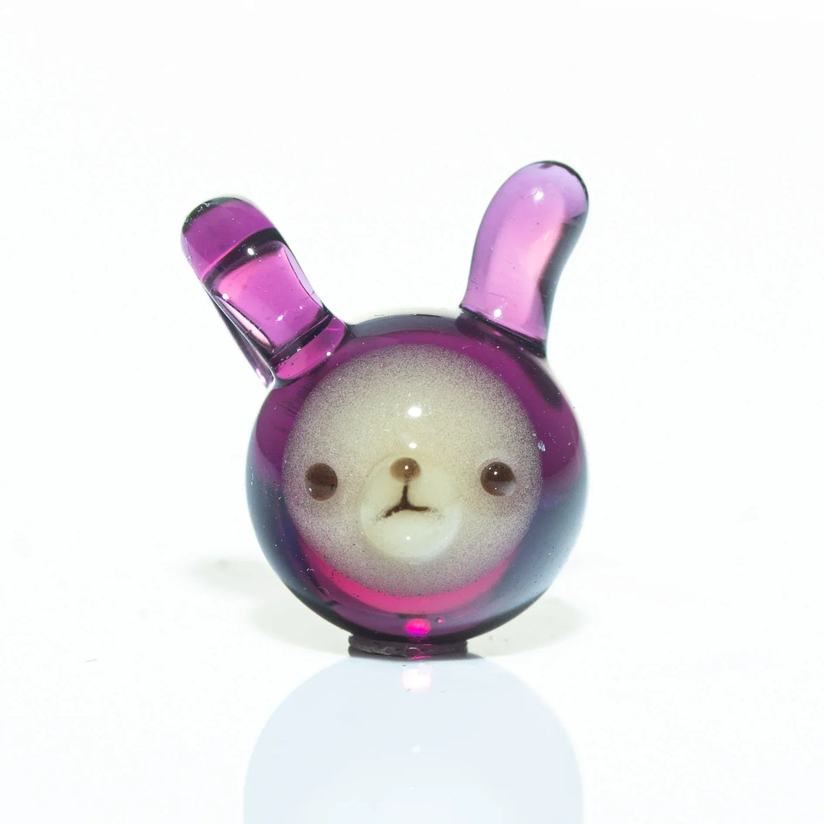 Purple glass pendant shaped like a bear face with upright ears on a white background