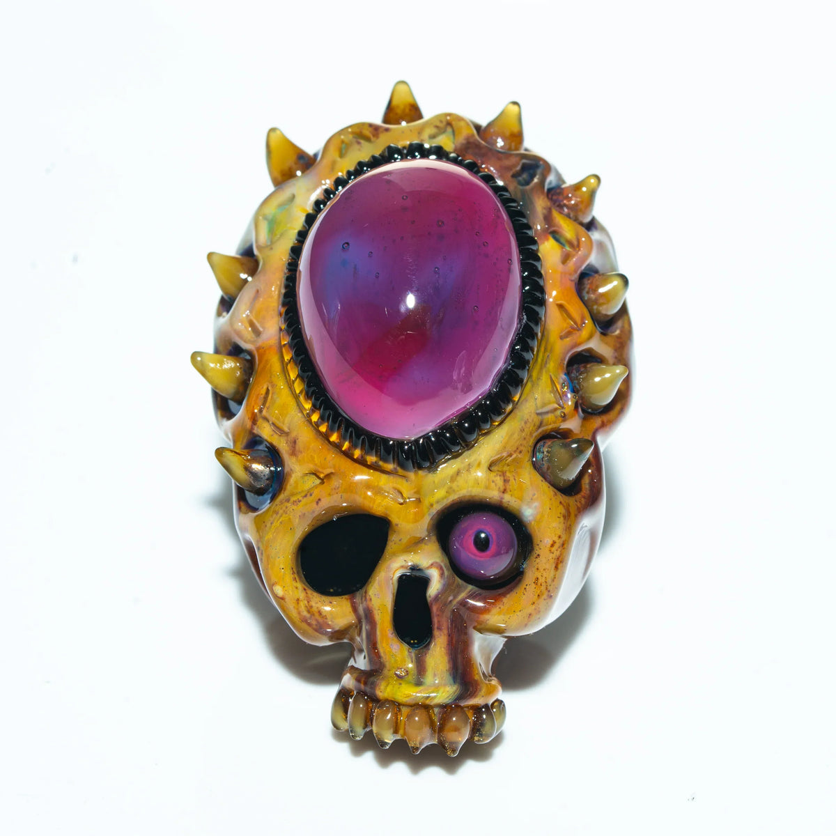 Glass skull pendant with gold spikes and a large purple gemstone centerpiece
