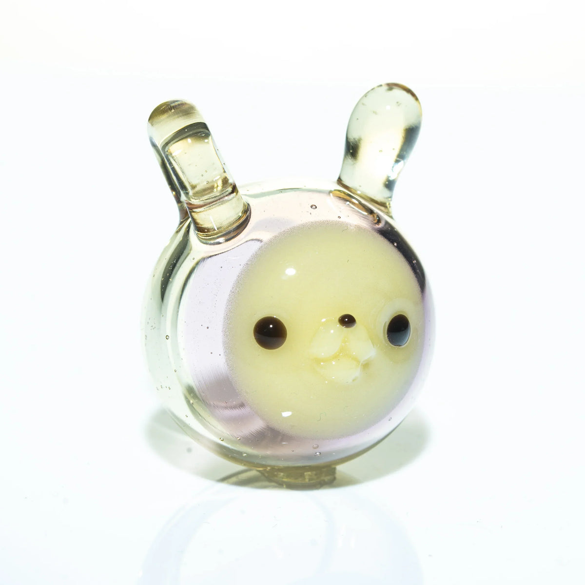 Clear glass pendant with yellow chubby animal face and upright ears on white background