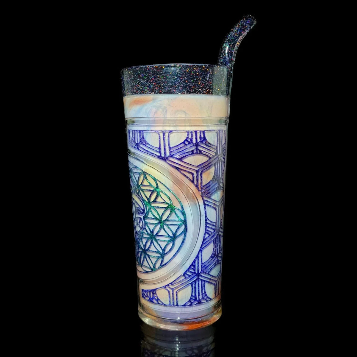 Intricate glass sippy cup with geometric patterns and colorful straw on black background