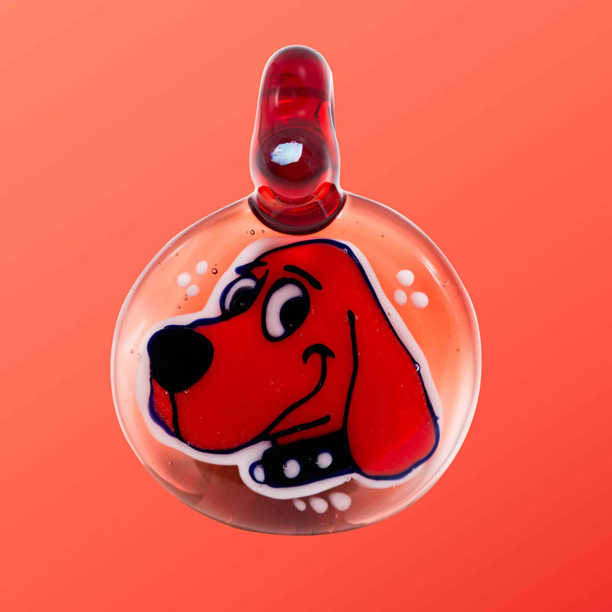 Handmade glass pendant featuring a red cartoon dog face on an orange background