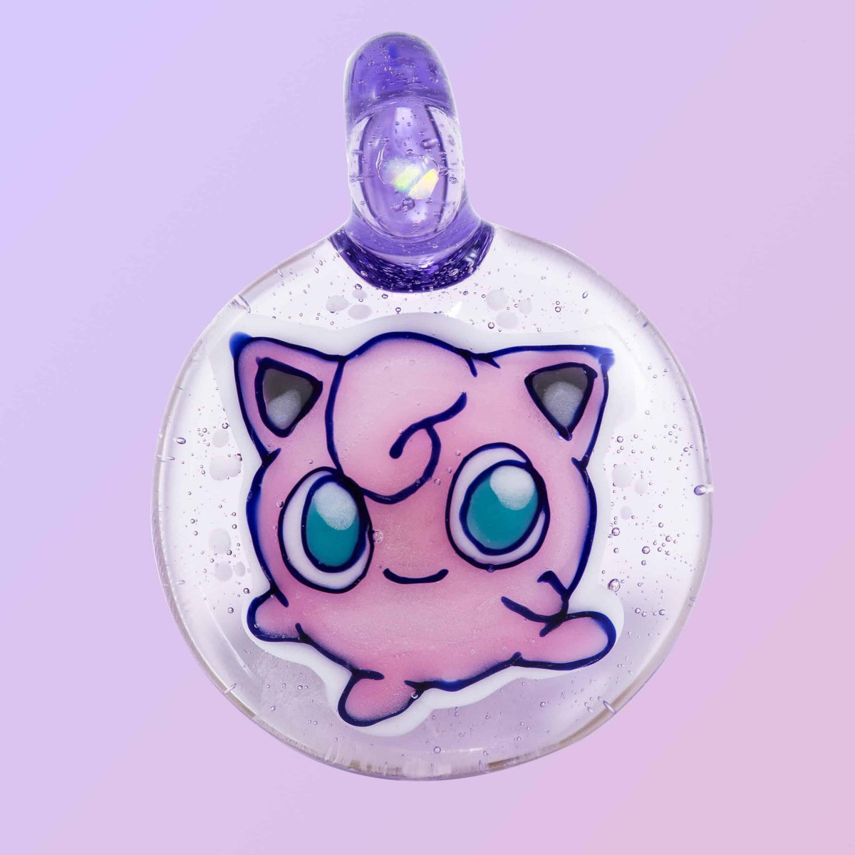 Handmade glass pendant featuring a pink cartoon character with big blue eyes on a purple background.