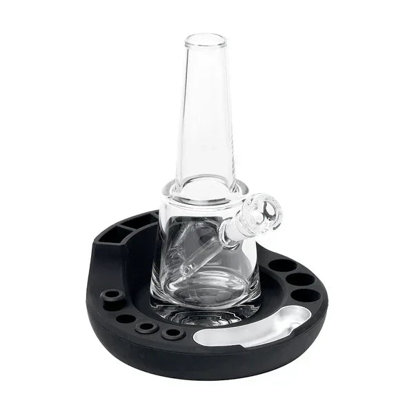 Clear glass water pipe with angled mouthpiece on a black silicone holder, smoking accessory