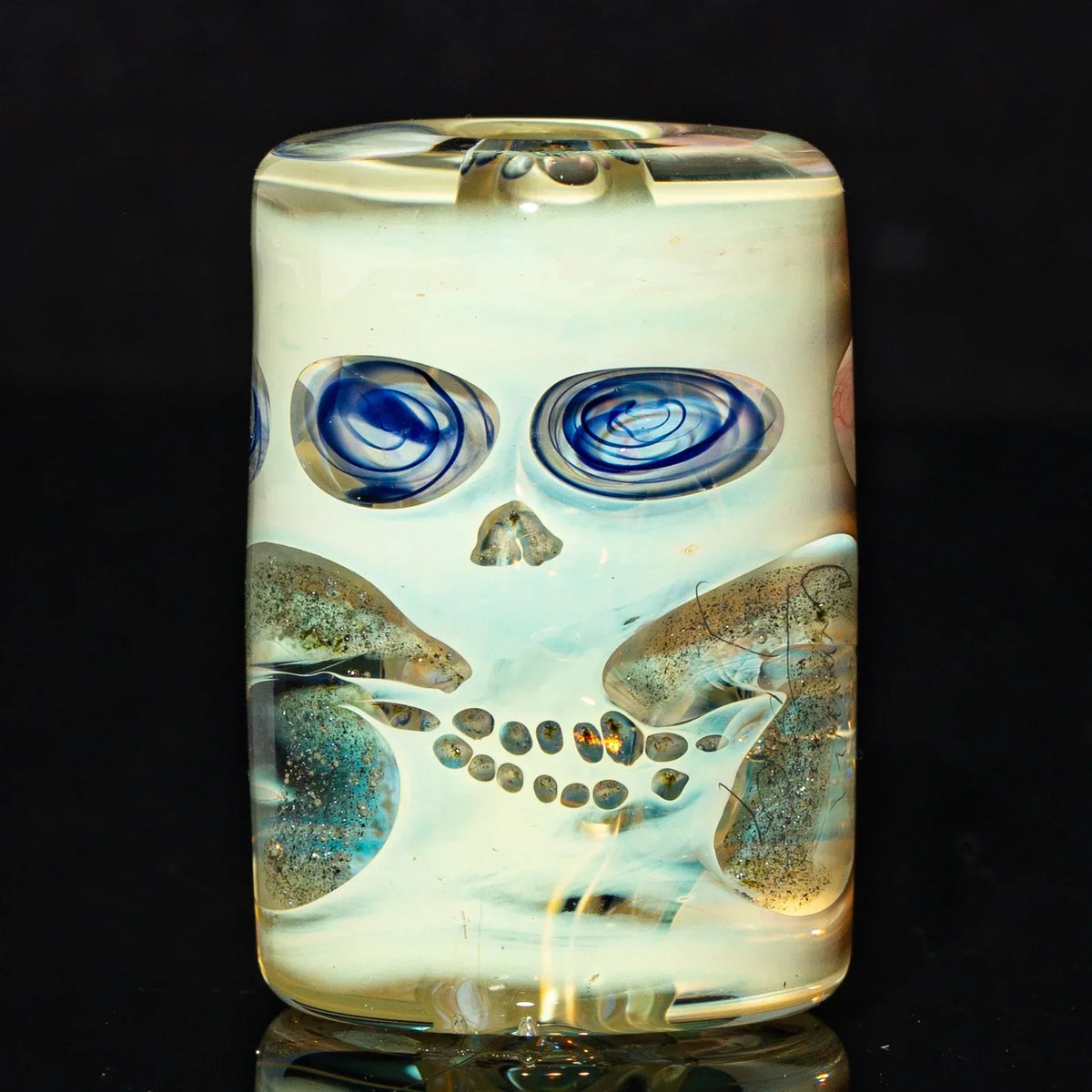 Handcrafted glass bead with artistic skull face design and vivid swirled blue eye details